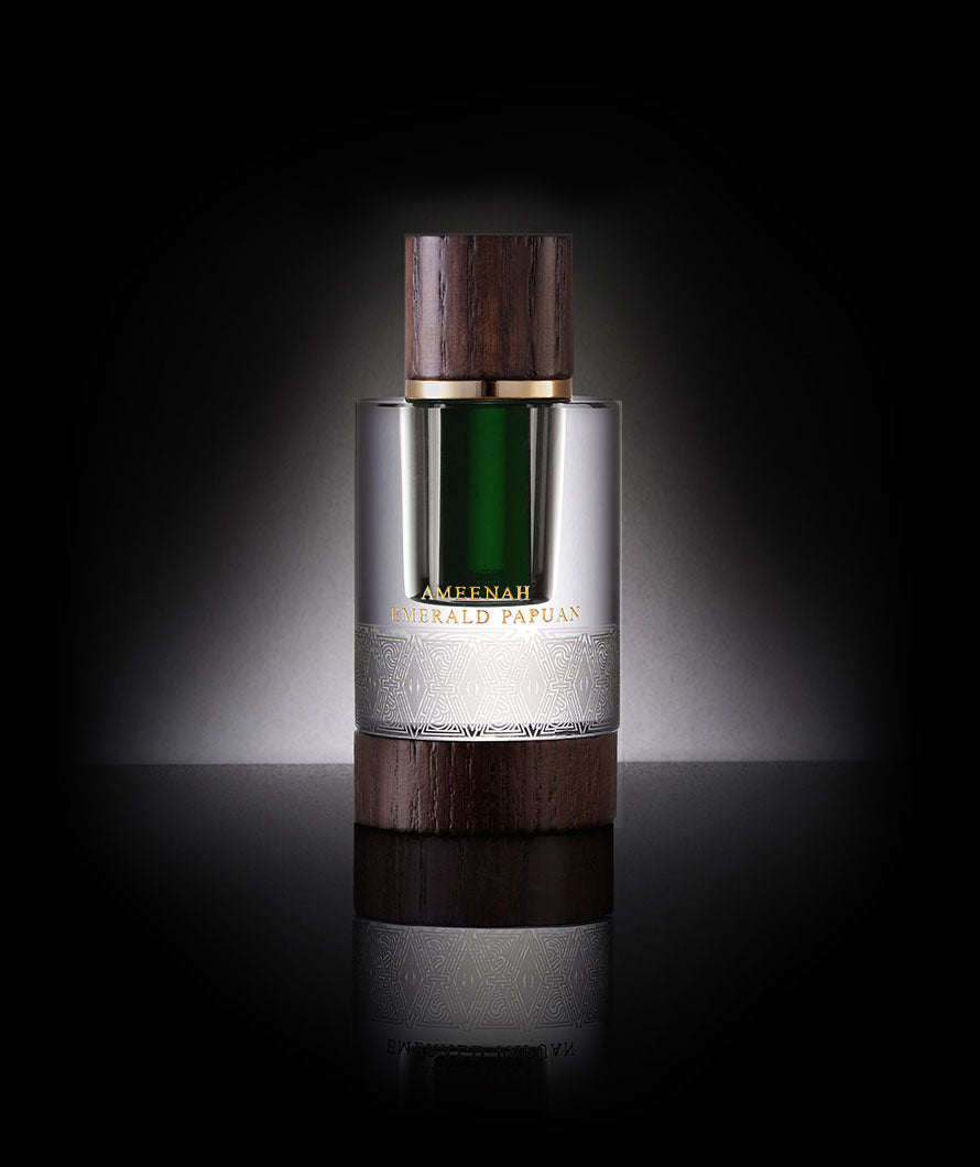 Close-up of Emerald Papuan Dehn Al Oud bottle a fresh, green, tropical oud oil with citrus and floral notes, reflecting vitality, uniqueness, and global appeal.